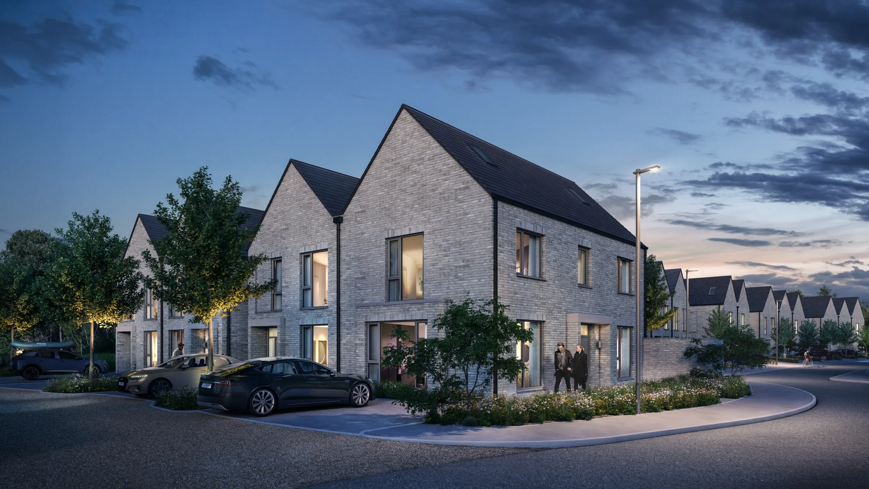 Modern terraced houses with landscaping and cars in the driveway