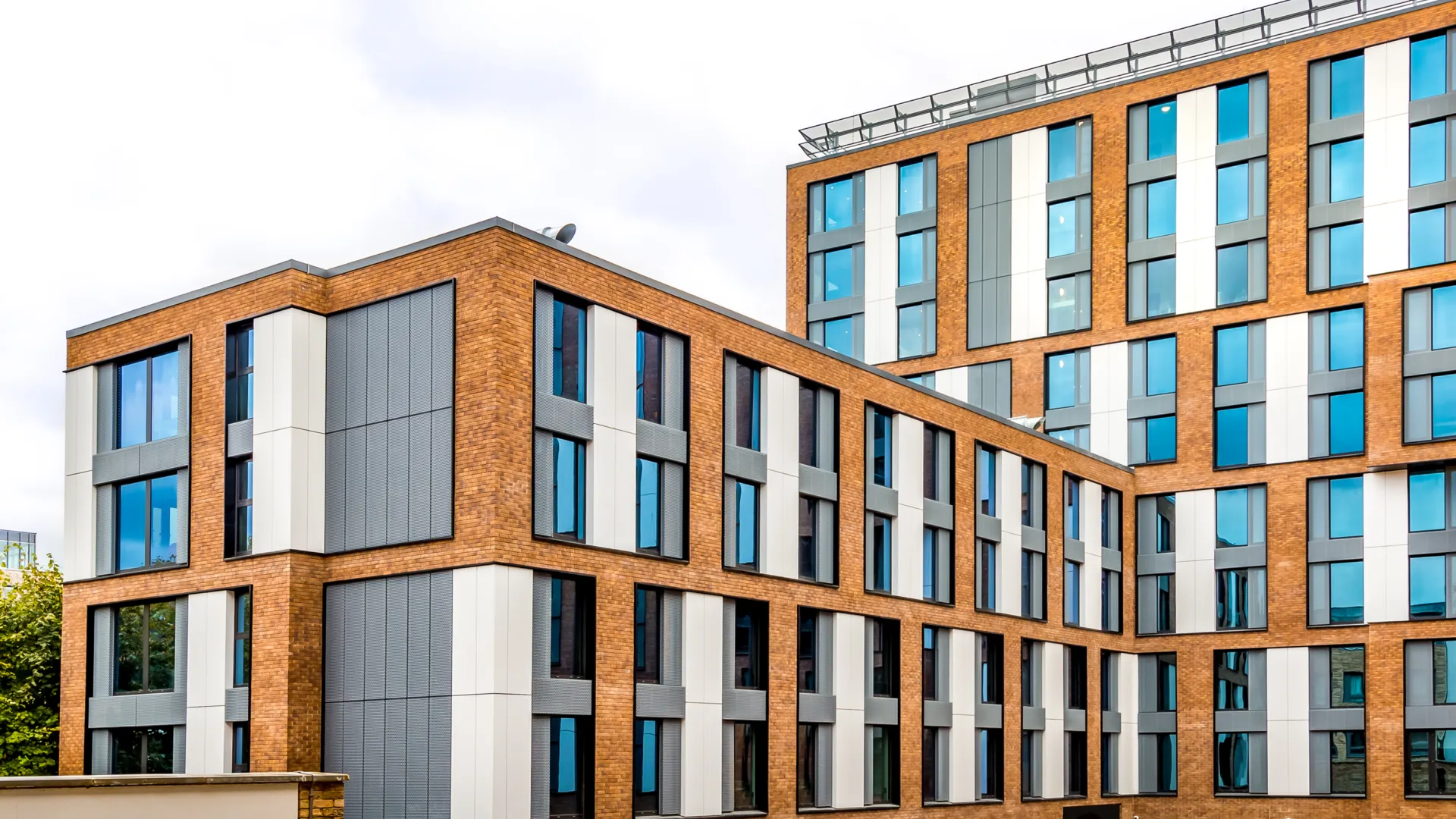 Facade of a student accommodation block showing the brickwork, windows and cladding panels