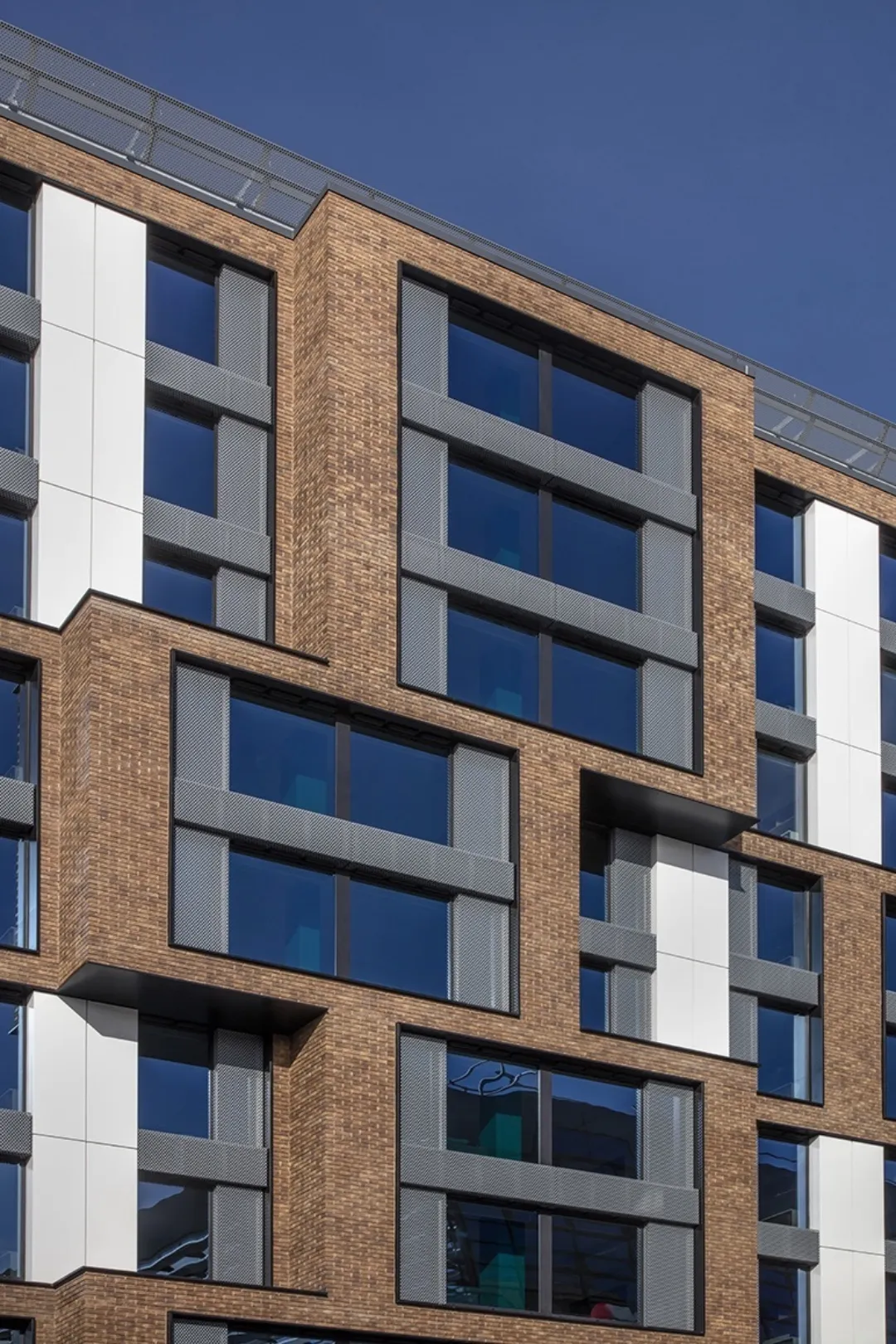 Architectural detail of a modern multi storey building with large windows off set to create a facade with multiple depths