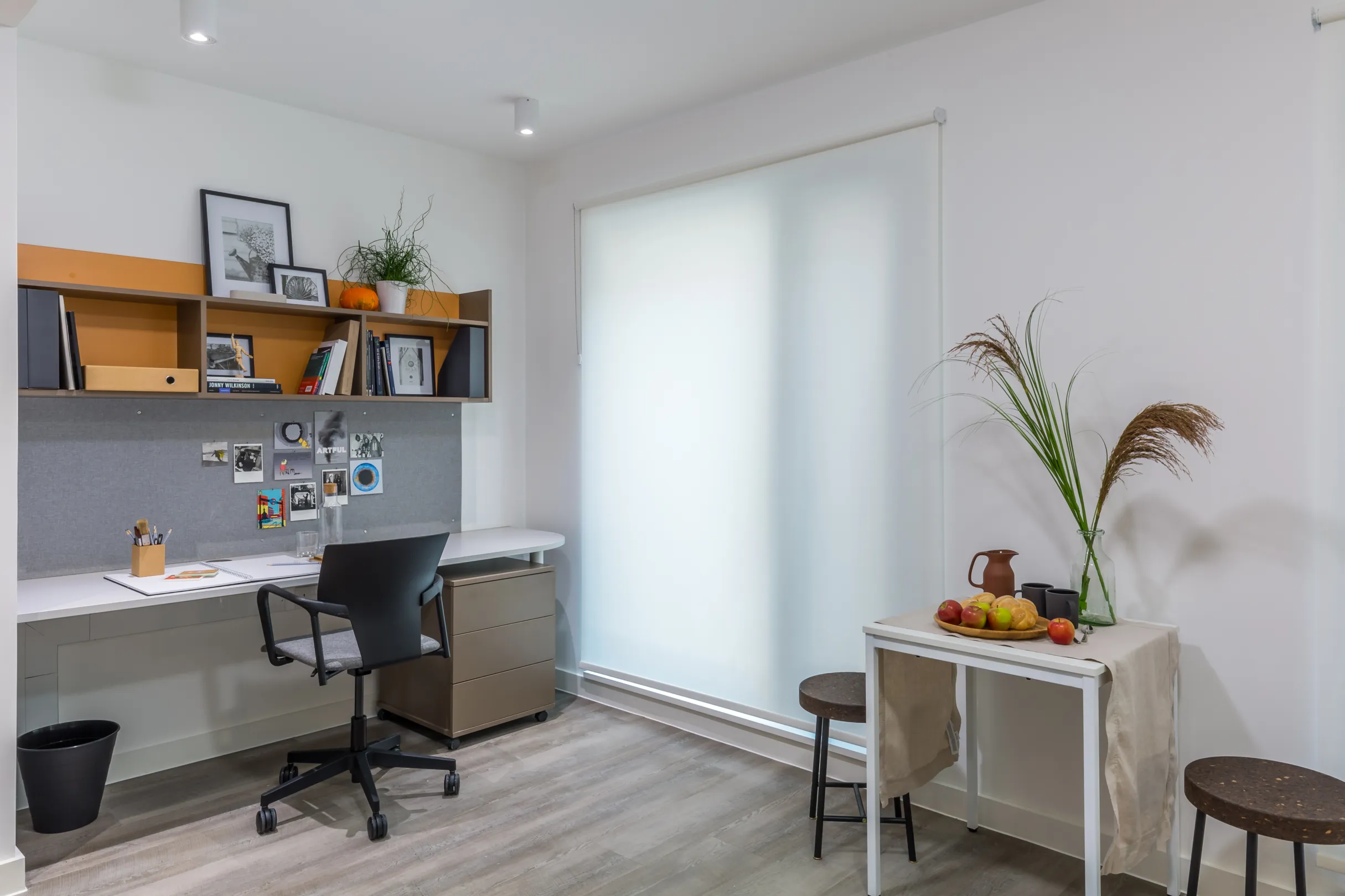 Studio room student accommodation showing a workdesk with storage shelves above and swivel chair