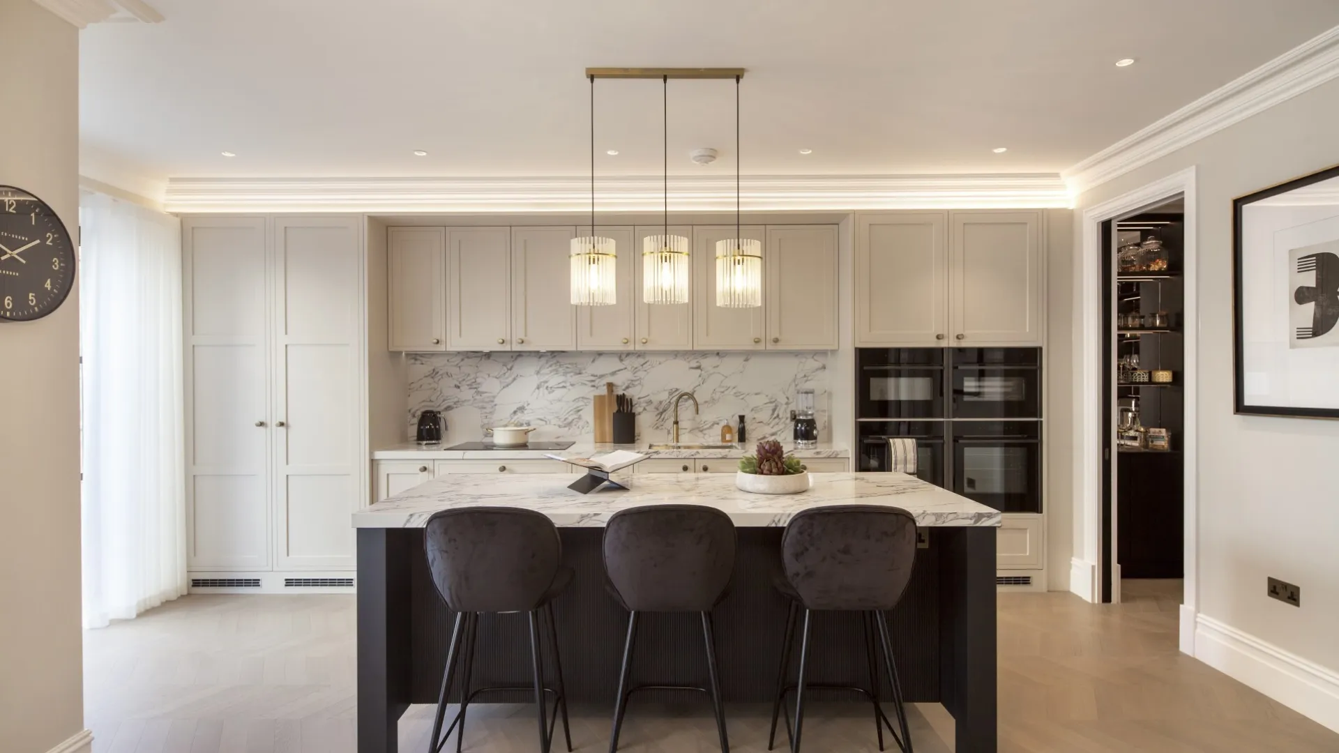 Kitchen (front view): A bespoke shaker kitchen with marble splashback, brass pendant lighting and a statement island for casual dining.