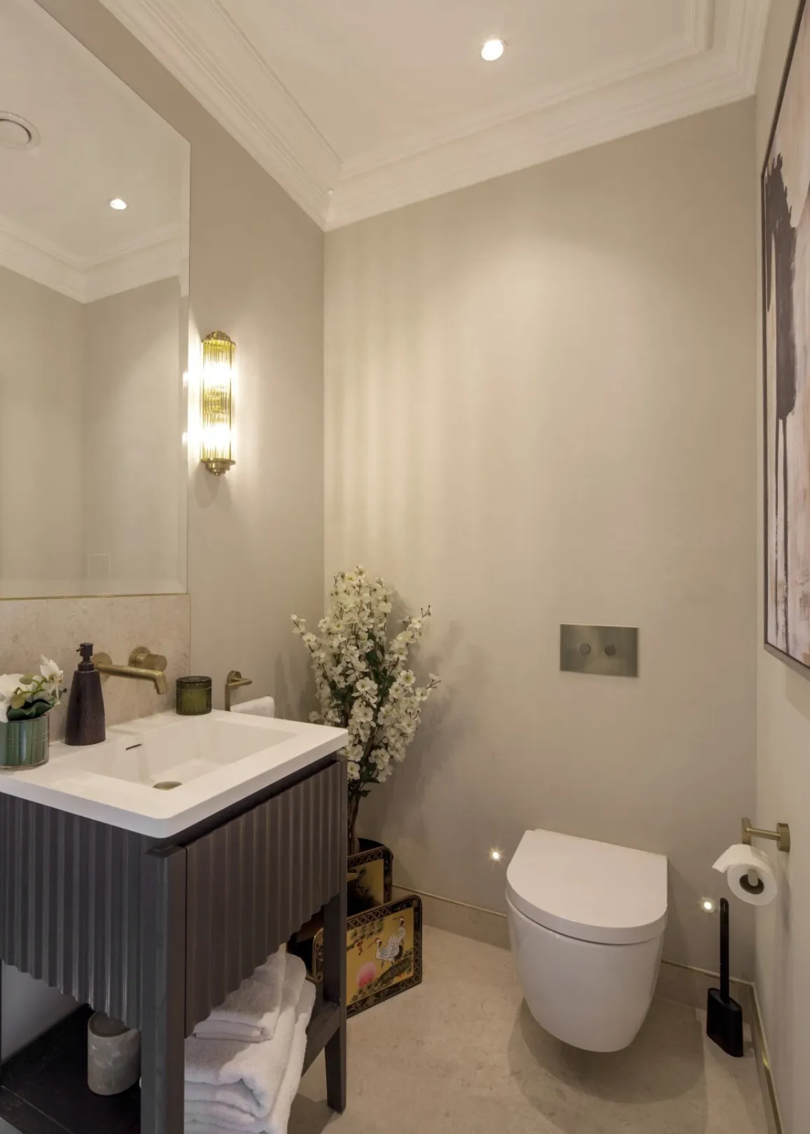Guest WC: An elegant cloakroom with fluted vanity, brushed brass fittings and soft ambient lighting.