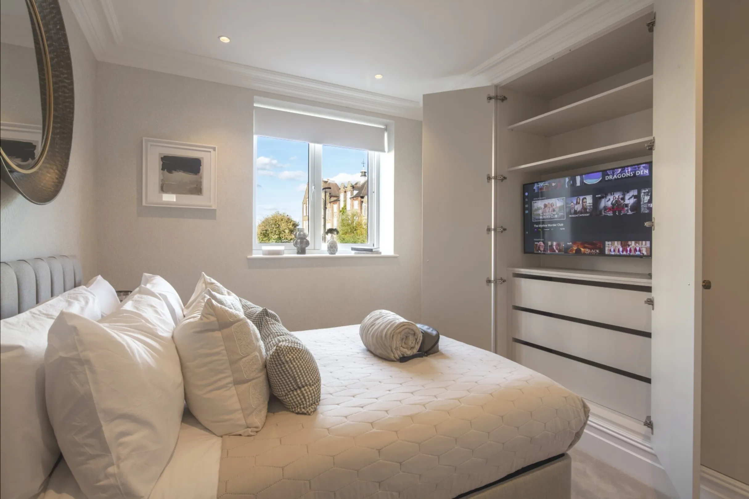 Guest bedroom: A calm double bedroom with fitted wardrobes concealing a built-in TV.