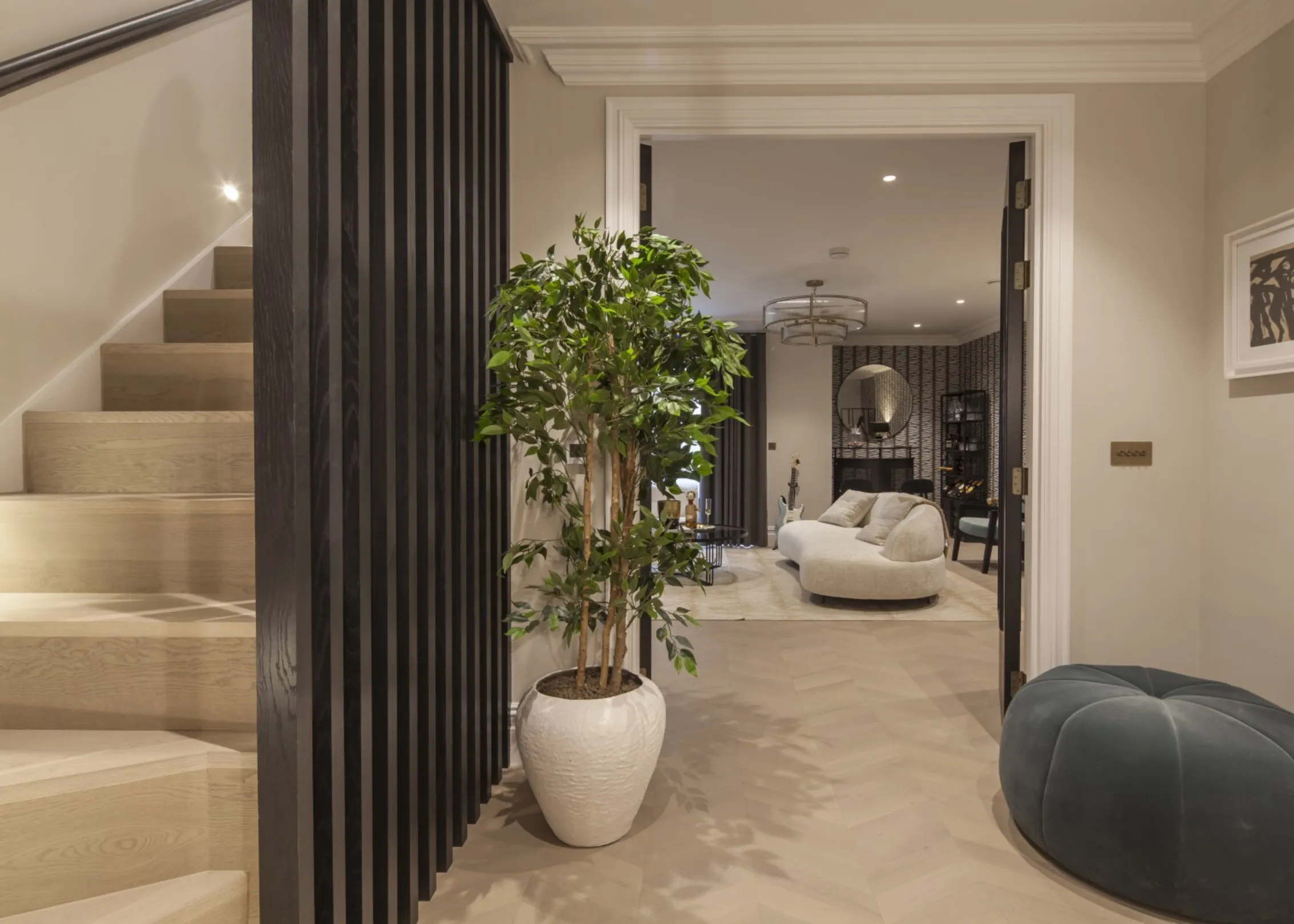 Lower-ground lobby: Oak effect stairs with a slatted timber screen descend to a stylish lobby opening onto the lower-ground entertaining lounge.