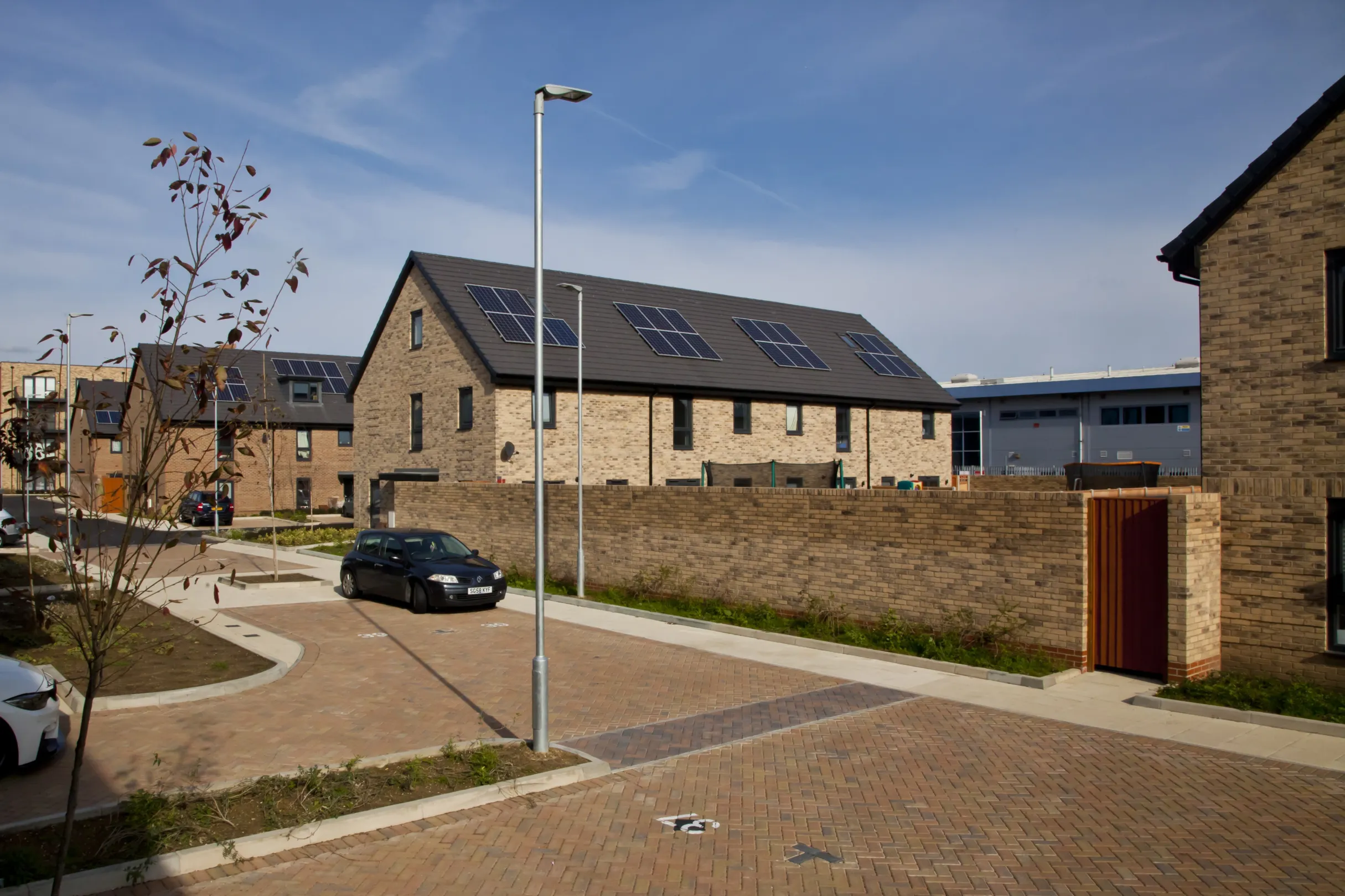 Modern terraced homes built in brick with walled rear gardens and solar panels on the roof.