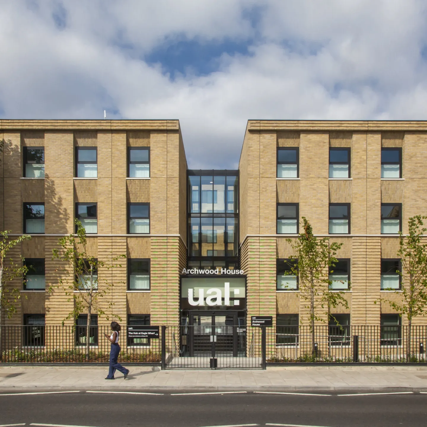 Facade of a modern four story building with central glazed atrium. A prominent sign above the door reads: Archwood House UAL