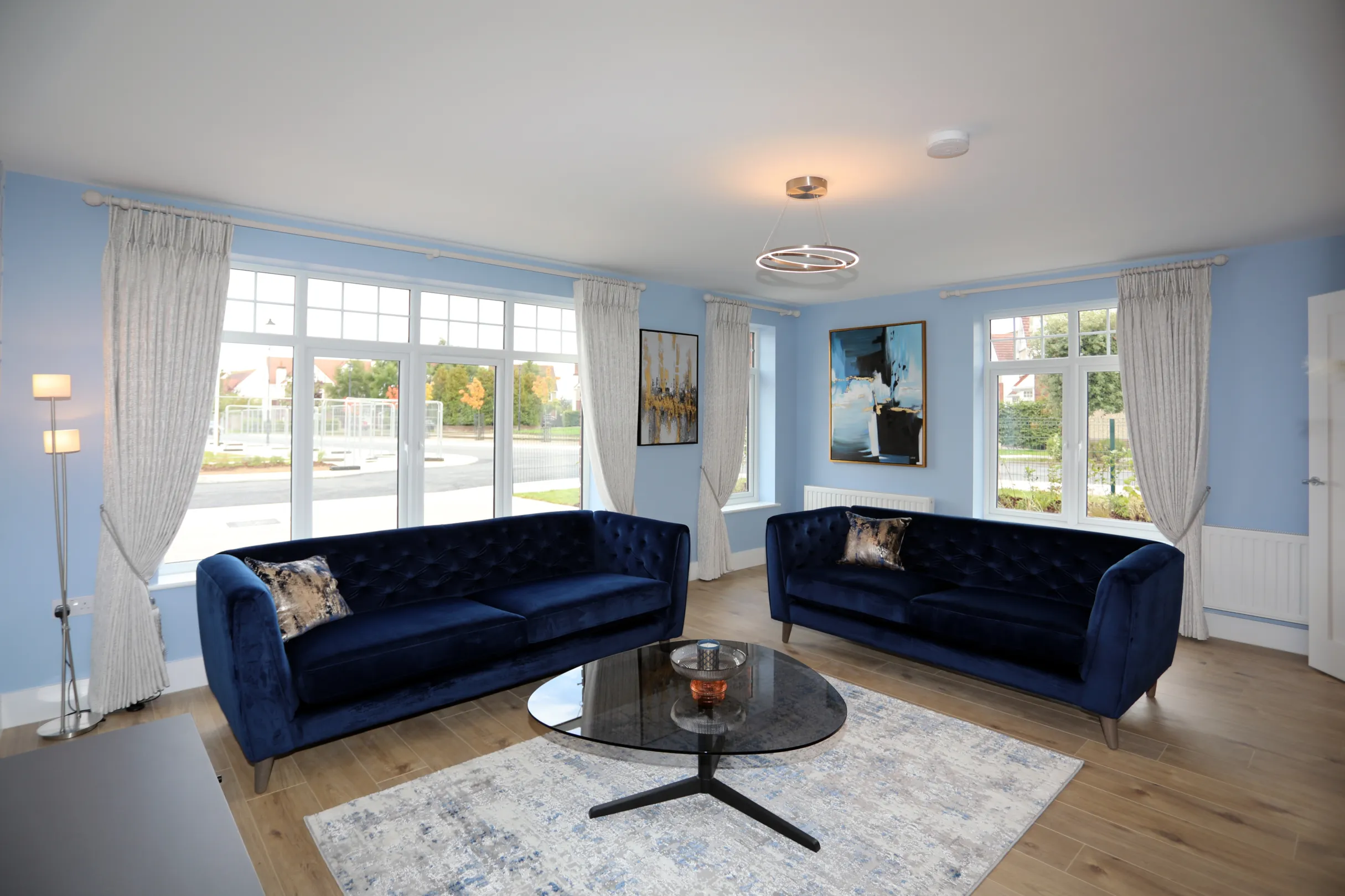 A modern living room with 2 navy blue sofas, coffee table, and TV unit