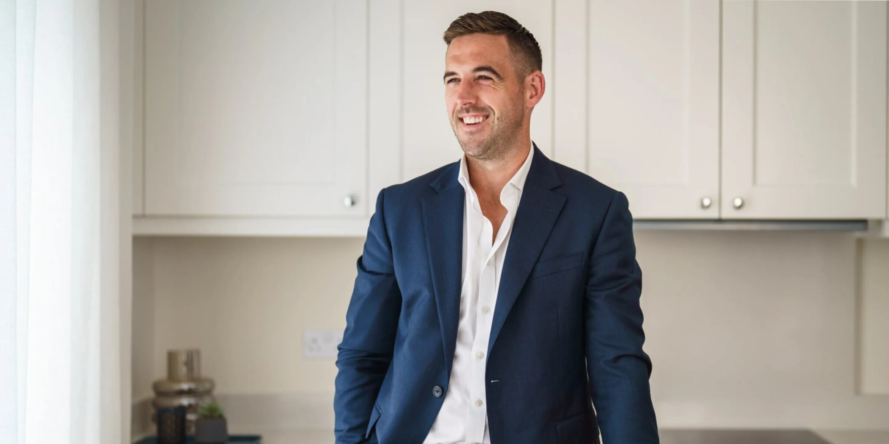 Man in a suit standing in a kitchen