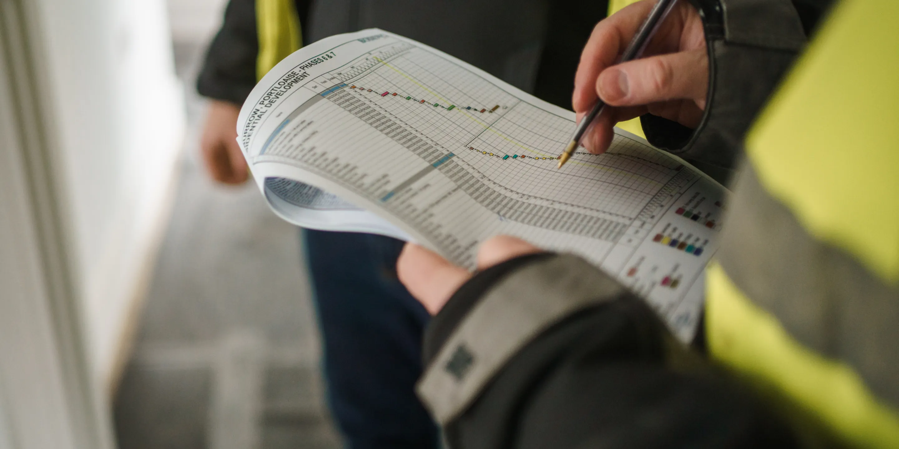 Workmen looking at a construction programme