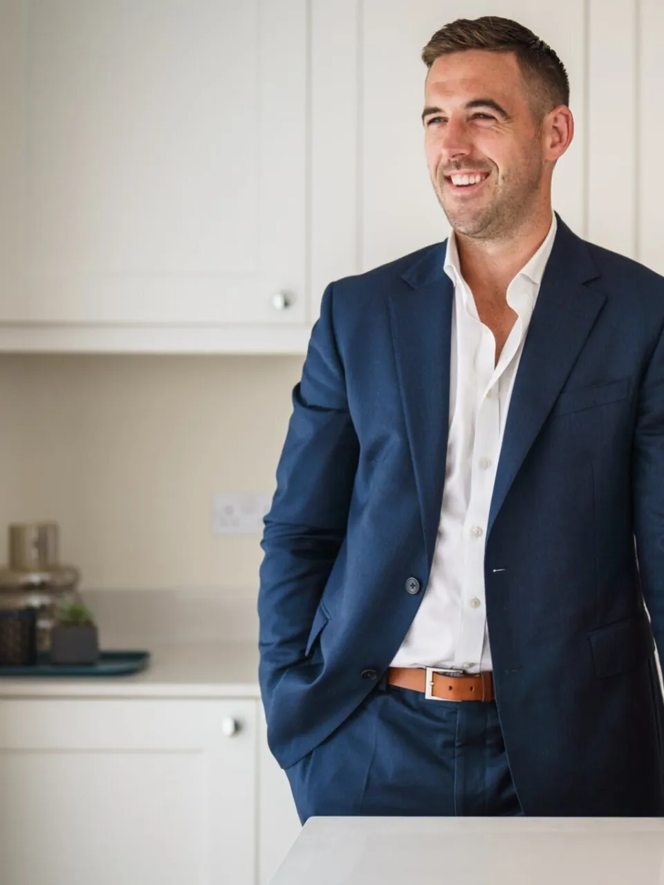 Man in a suit standing in a kitchen