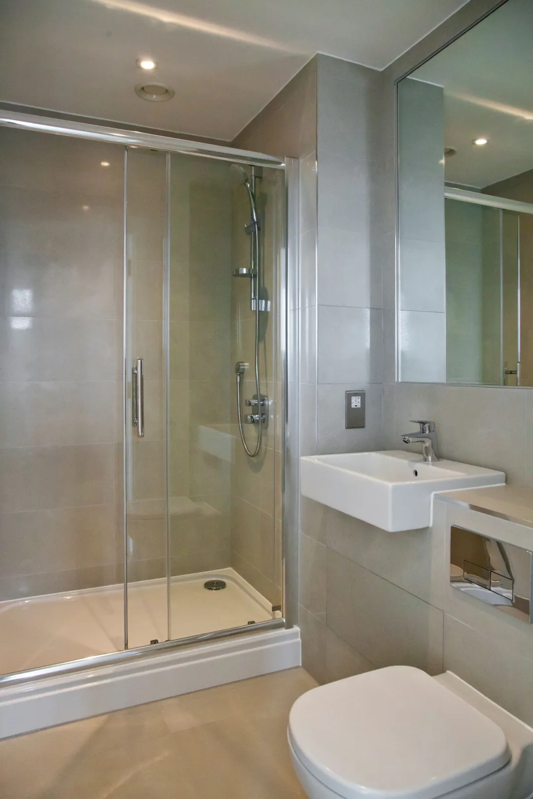 New build development, showing an ensuite, a large shower cubicle, basin and pan fully tiled throughout and large mirror above the basin
