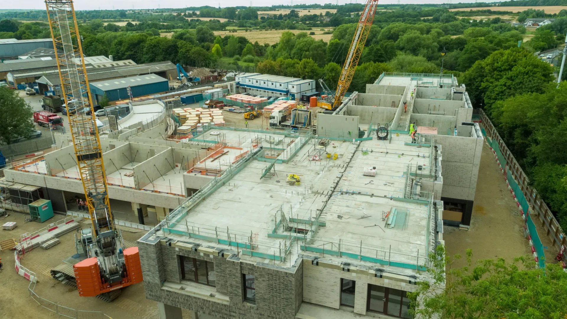 A construction site is busy with cranes and building materials as a large structure takes shape.