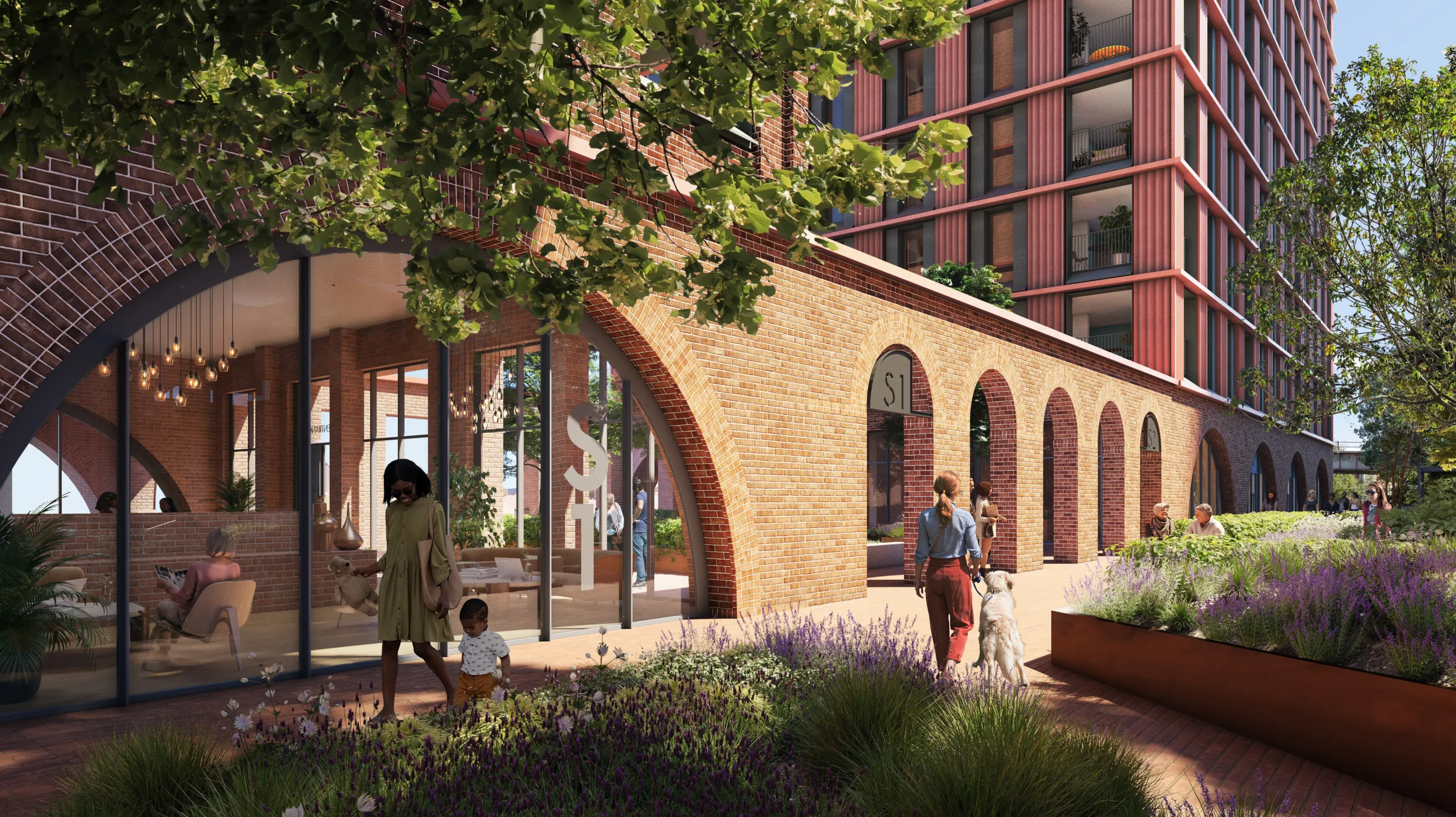 A large residential building rises above brick arches housing commercial space at ground level. Pedestrians are seen walking and relaxing in the planted area outside.