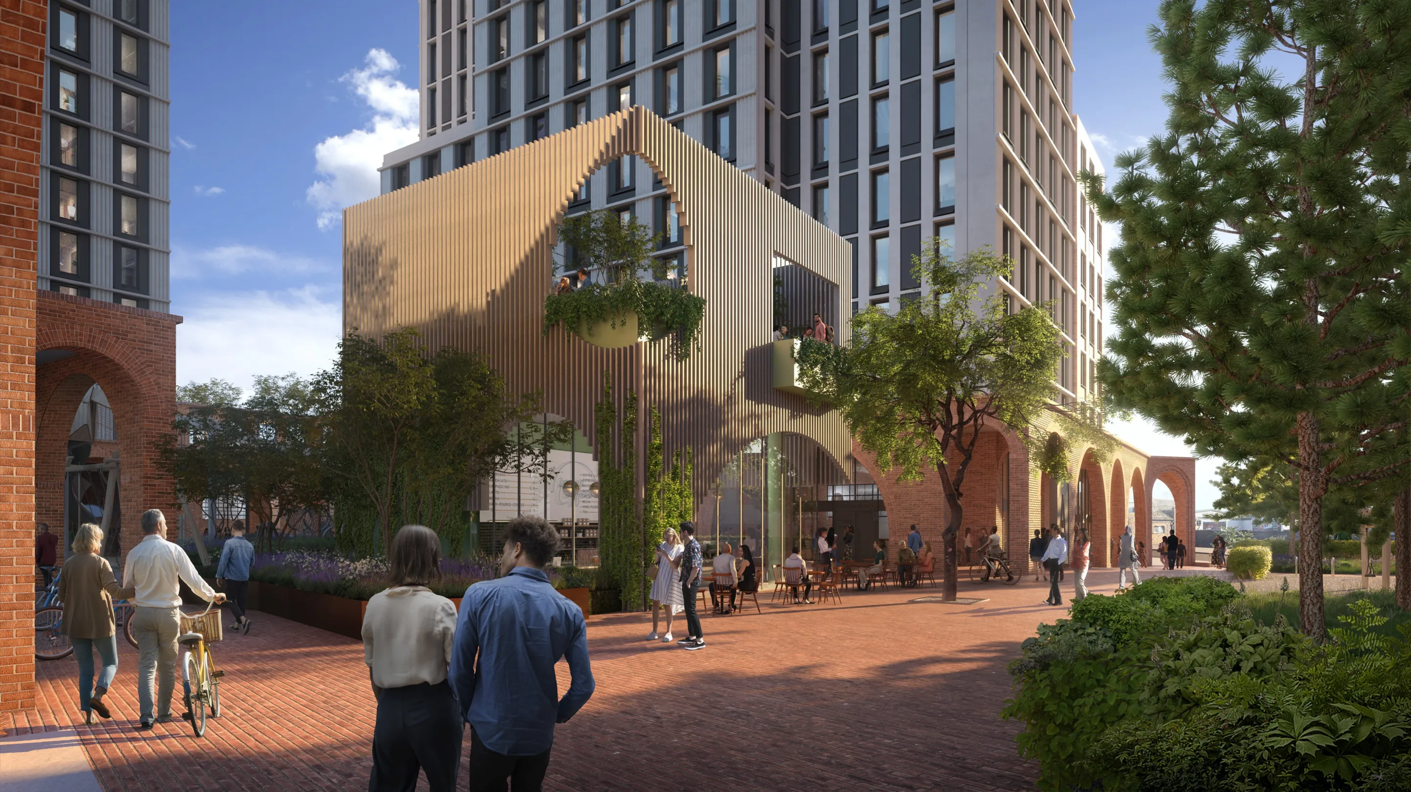 A large residential building rises behind commercial space at ground level, dominated by a metalwork facade and and planting. Pedestrians are seen walking and relaxing outside.