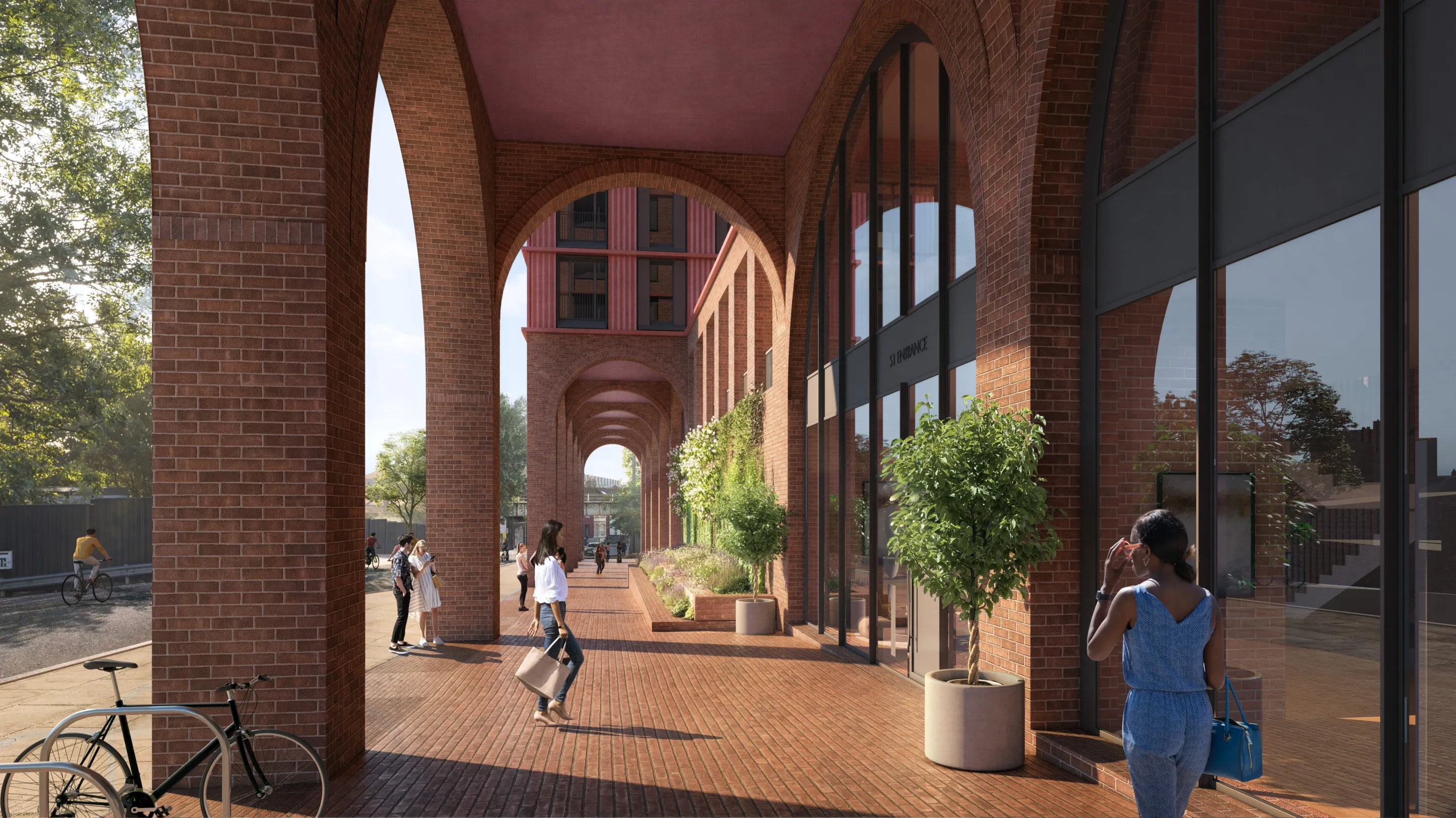 Pedestrians walking underneath large brick arches housing commercial space.