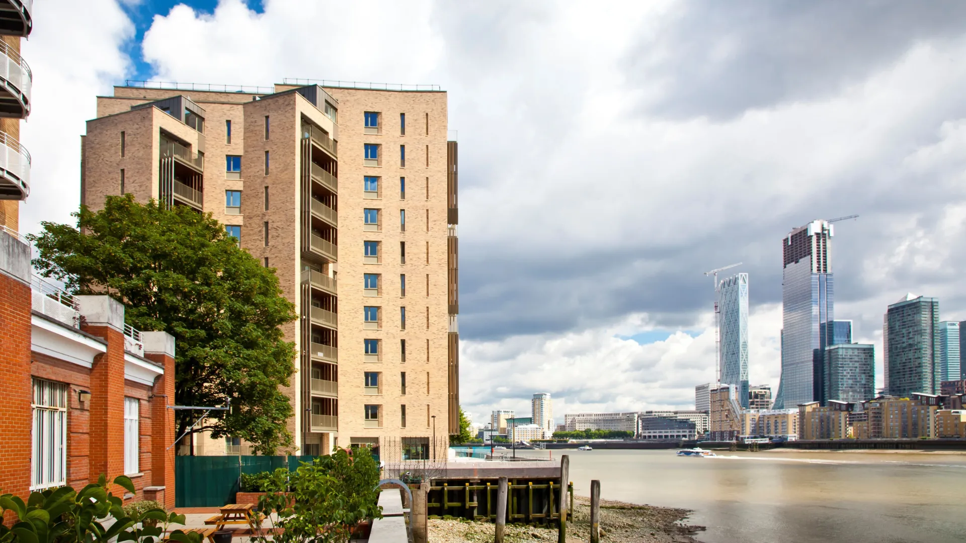 A modern multi storey residential building on the bank of the Thames, viewed from water level.