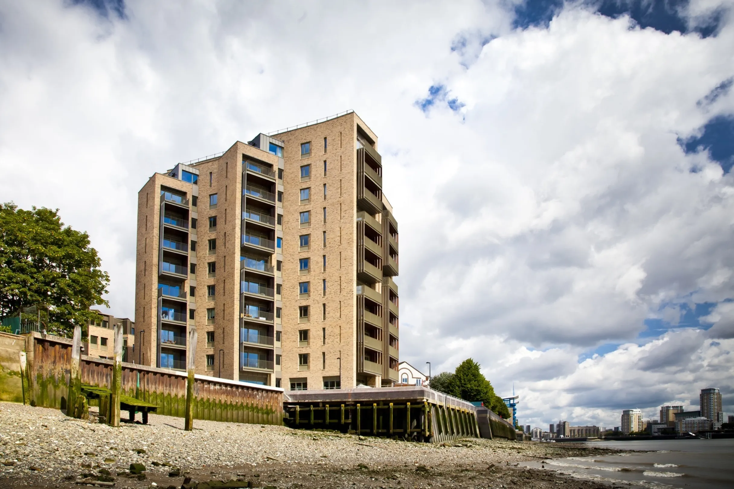 A modern multi storey residential building on the bank of the Thames, viewed from water level.