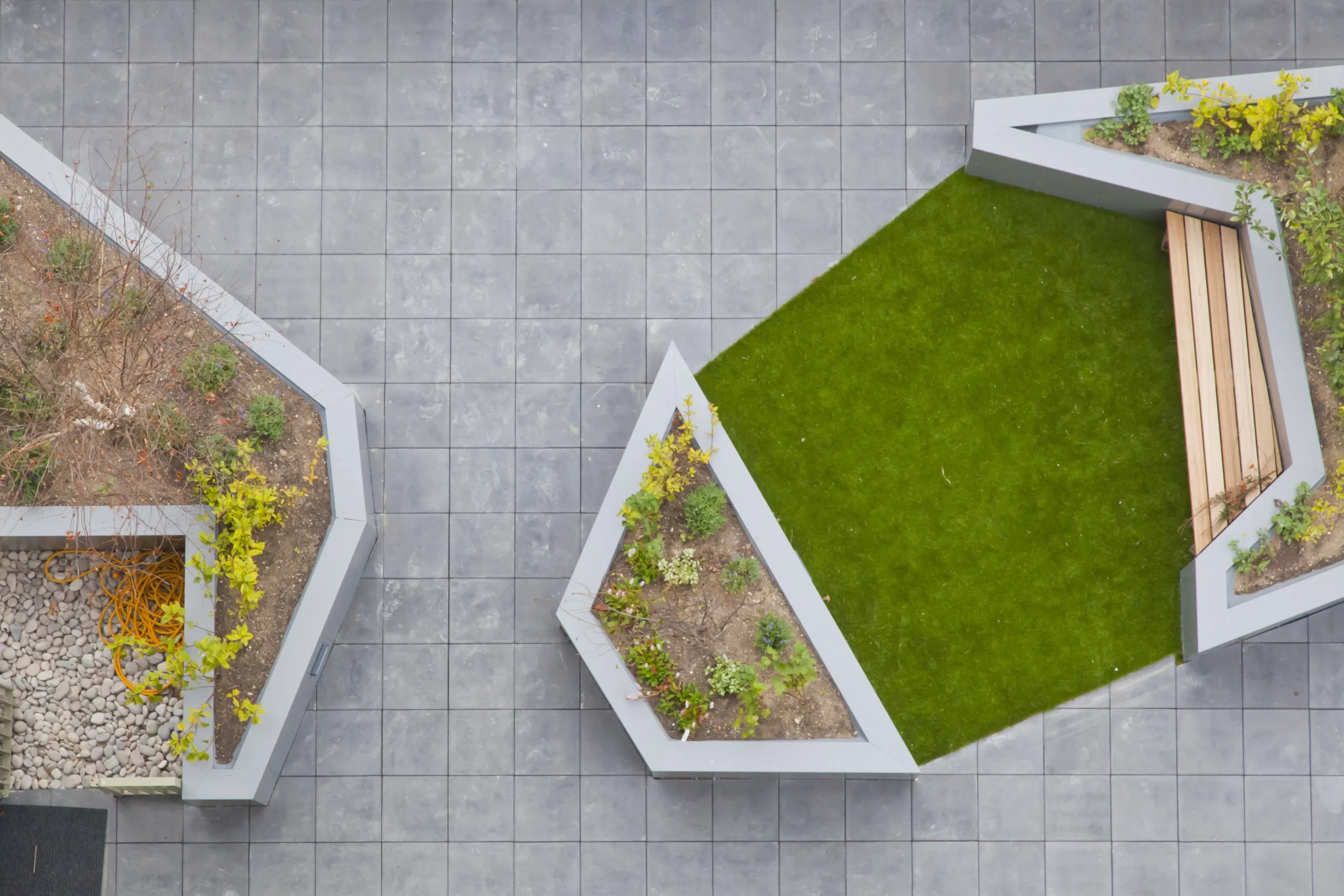 Modern roof garden from above showing grass, planters and square paving