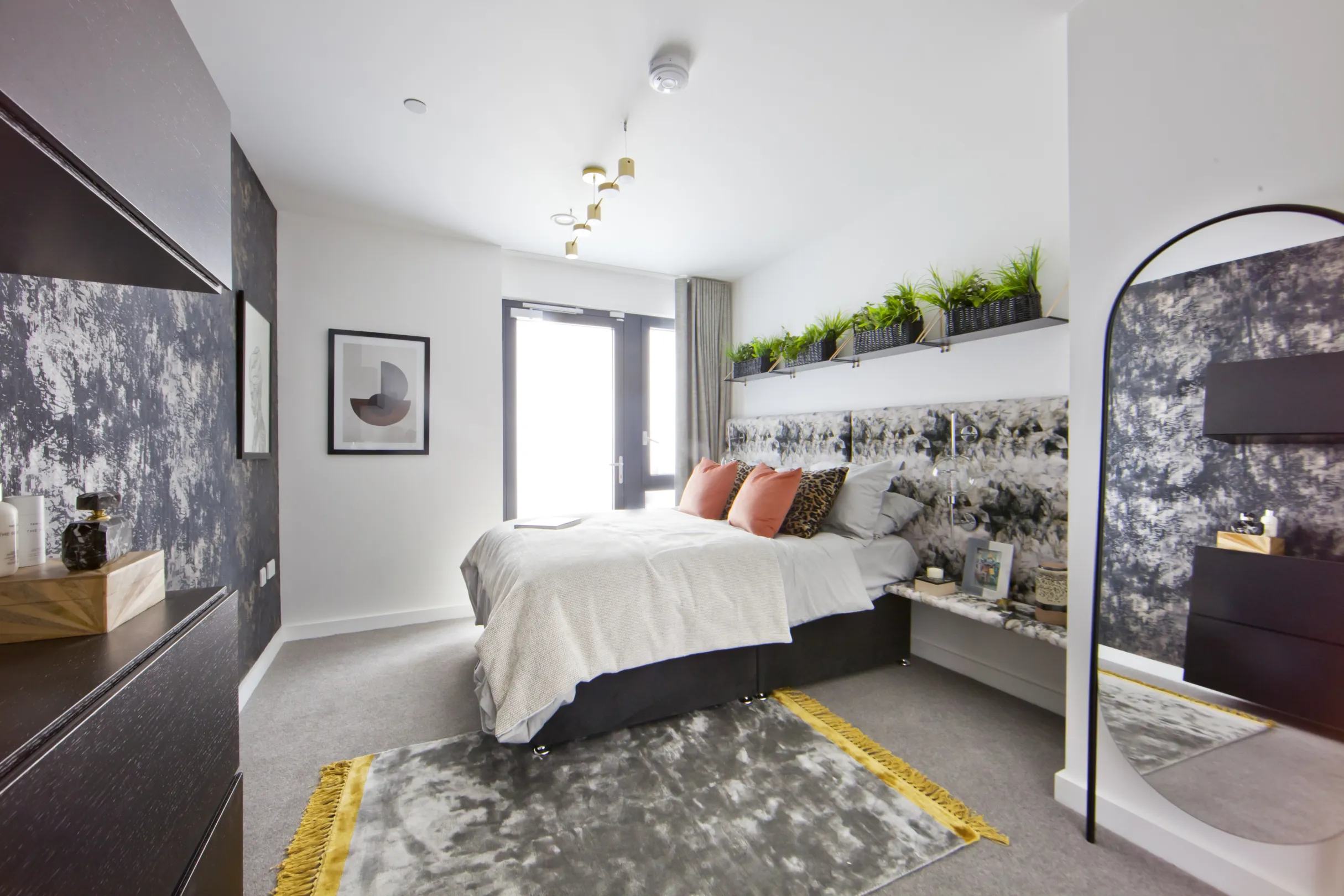 Bedroom in a modern residential building with floor to ceiling windows and designer furnishings