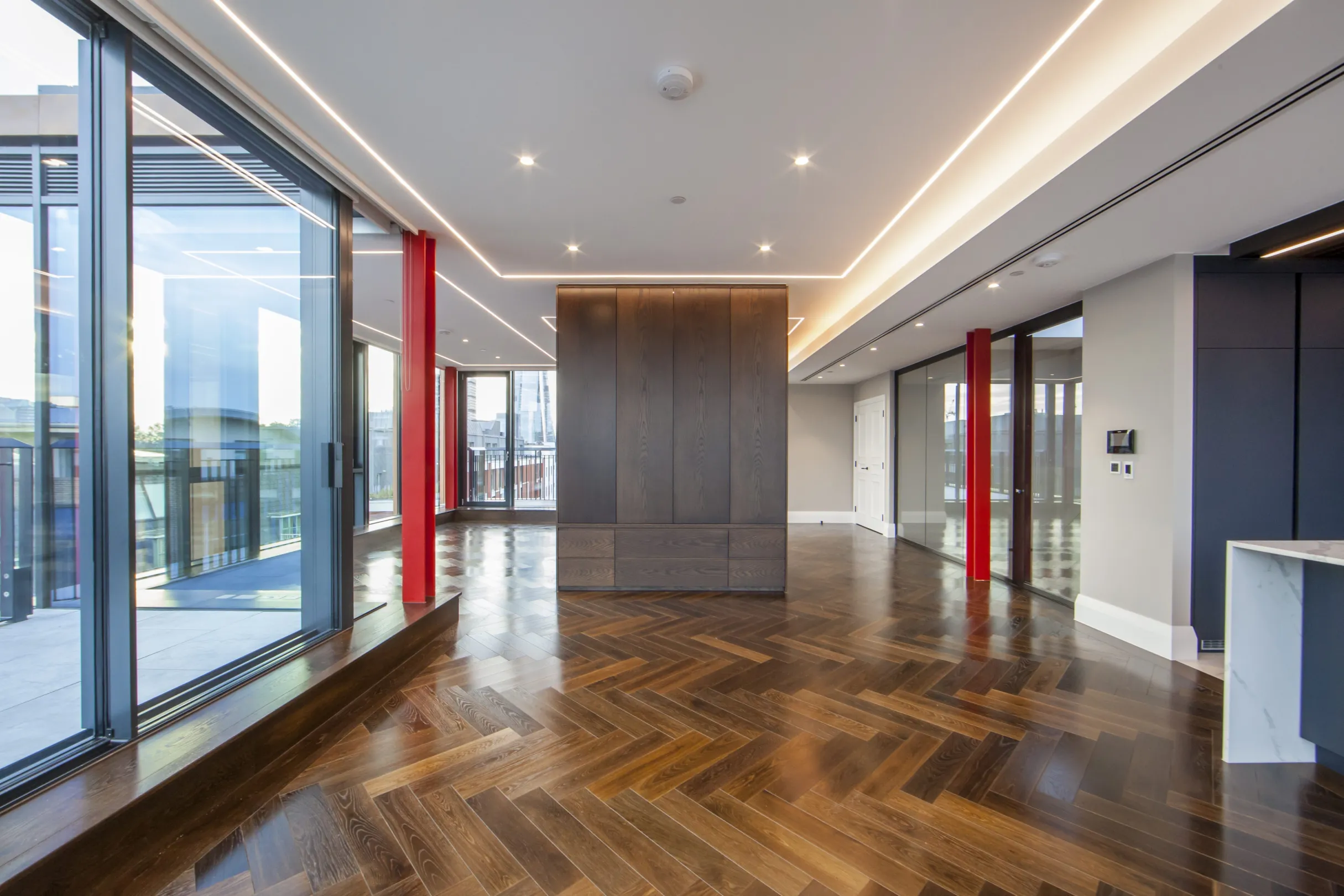 Luxury interior of a dual aspect apartment with floor to ceiling windows leading to a corner balcony and roof terrace. the shard is in the far distance.