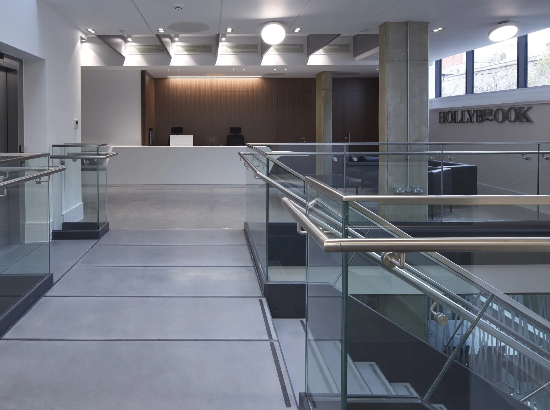 Modern office interior reception foyer with staircase and sign reading HOLLYBROOK