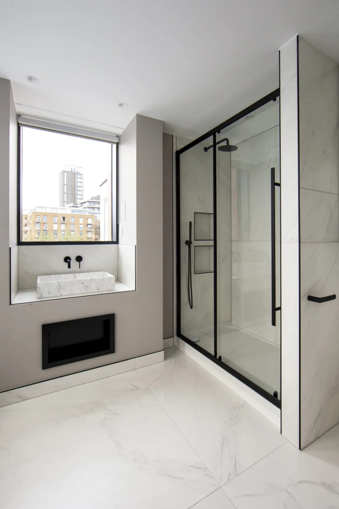 Modern bathroom with marble tiles and walk-in shower.