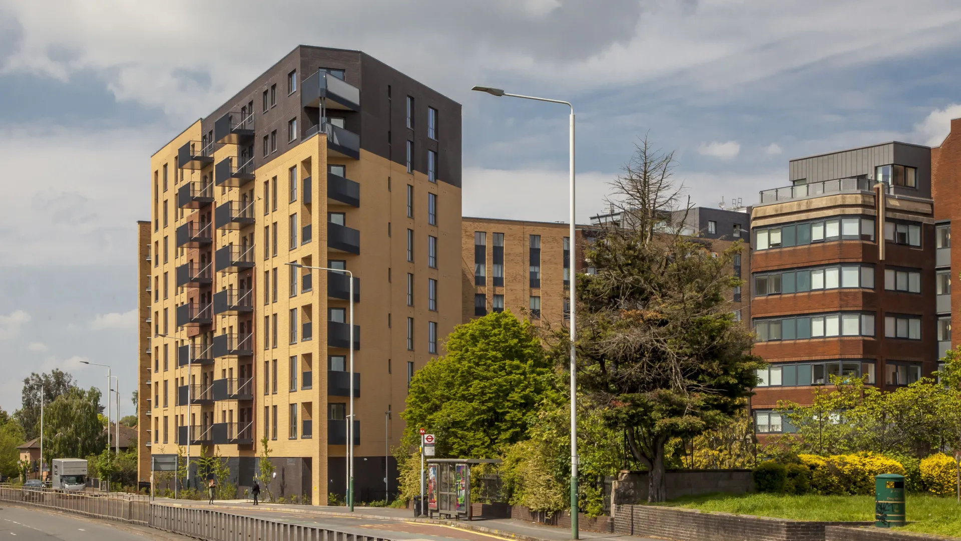 A new build block of flats, yellow brick facade with balconies located on Romford