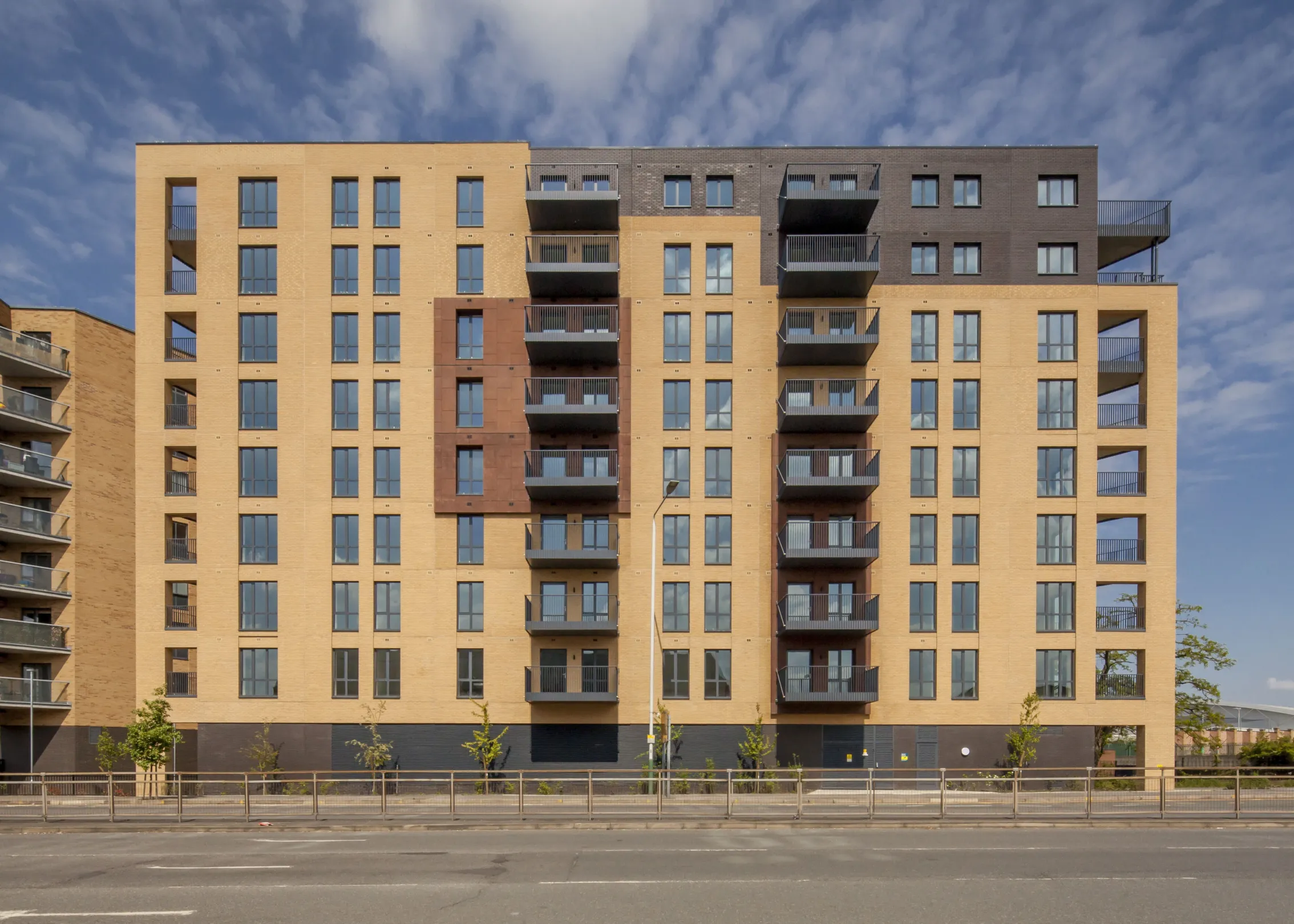 View from the road of a 9 storey residential building with balconies at every level