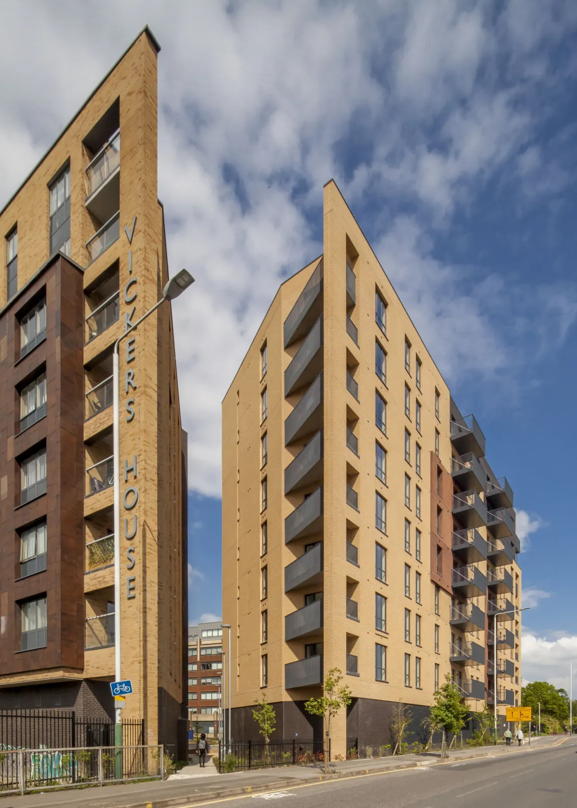 9 storey residential building with balconies and sand-coloured brickwork