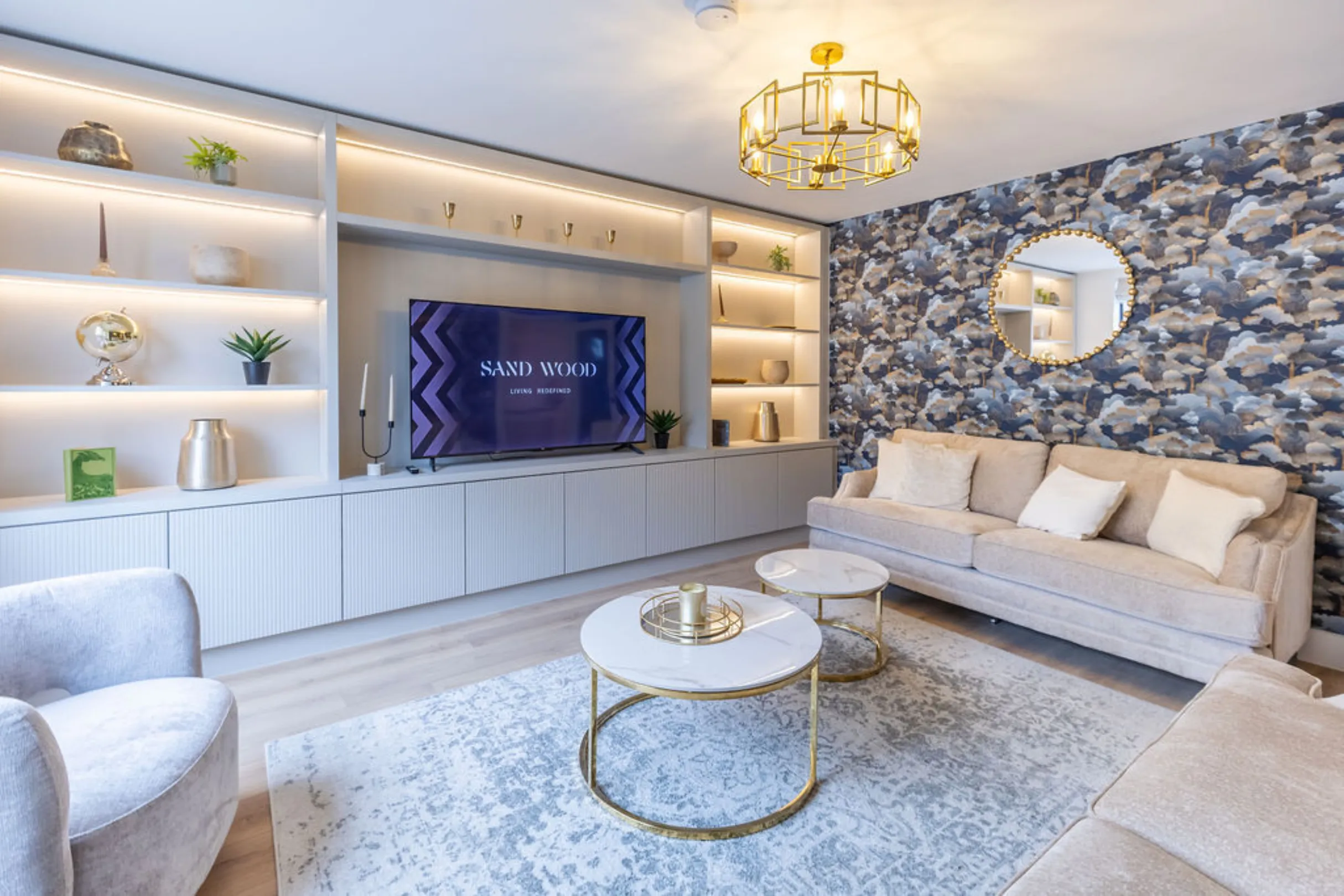 The image showcases a modern living room with a neutral color palette and stylish decor. The room features a sofa, a coffee table, a built-in entertainment unit