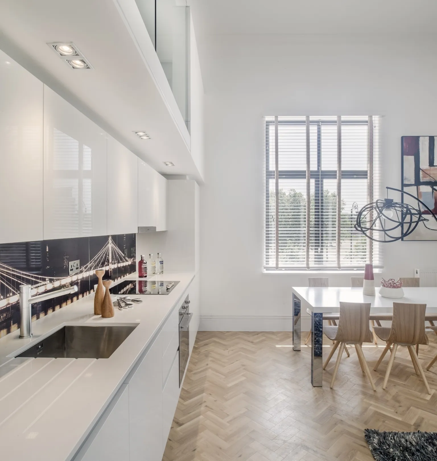 Modern kitchen and living space with parquet floor and designer furniture