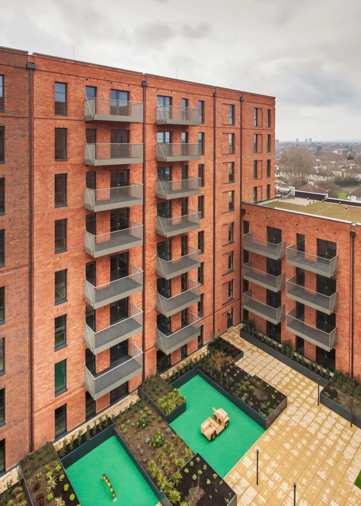 A new build red brick building with green roofs in Dagenham
