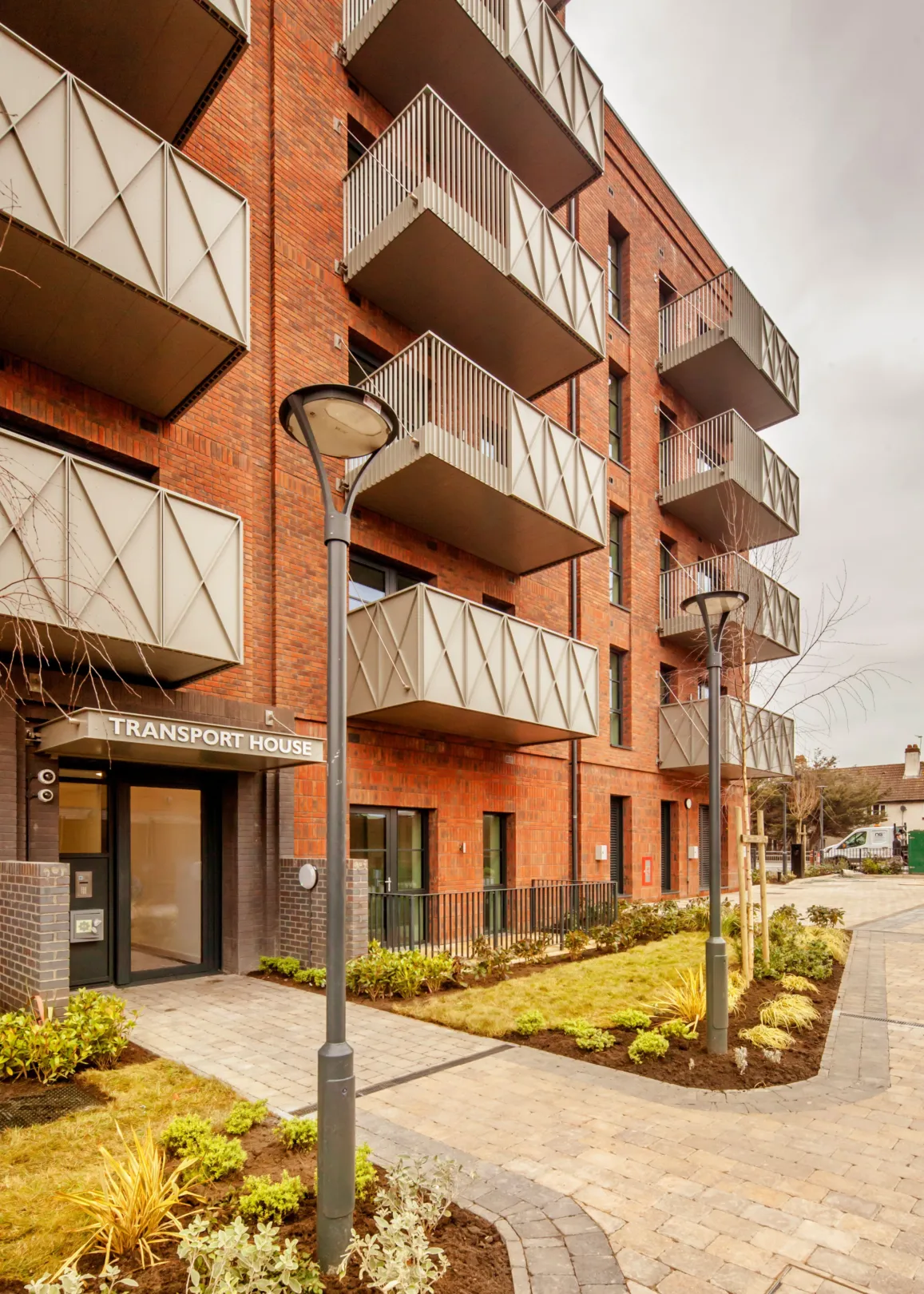 A new build red brick building with green roofs in Dagenham