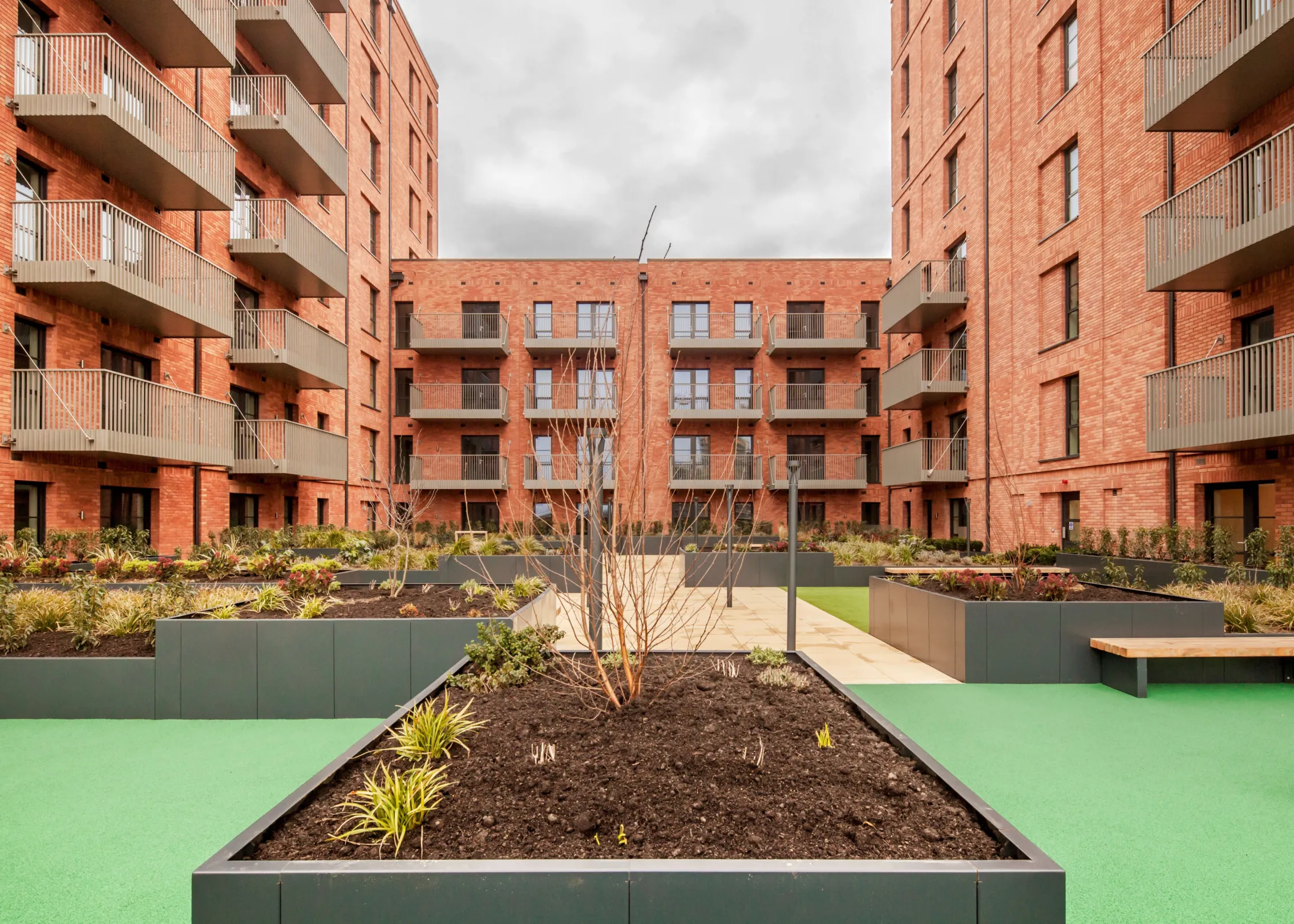 A new build red brick building with green roofs in Dagenham