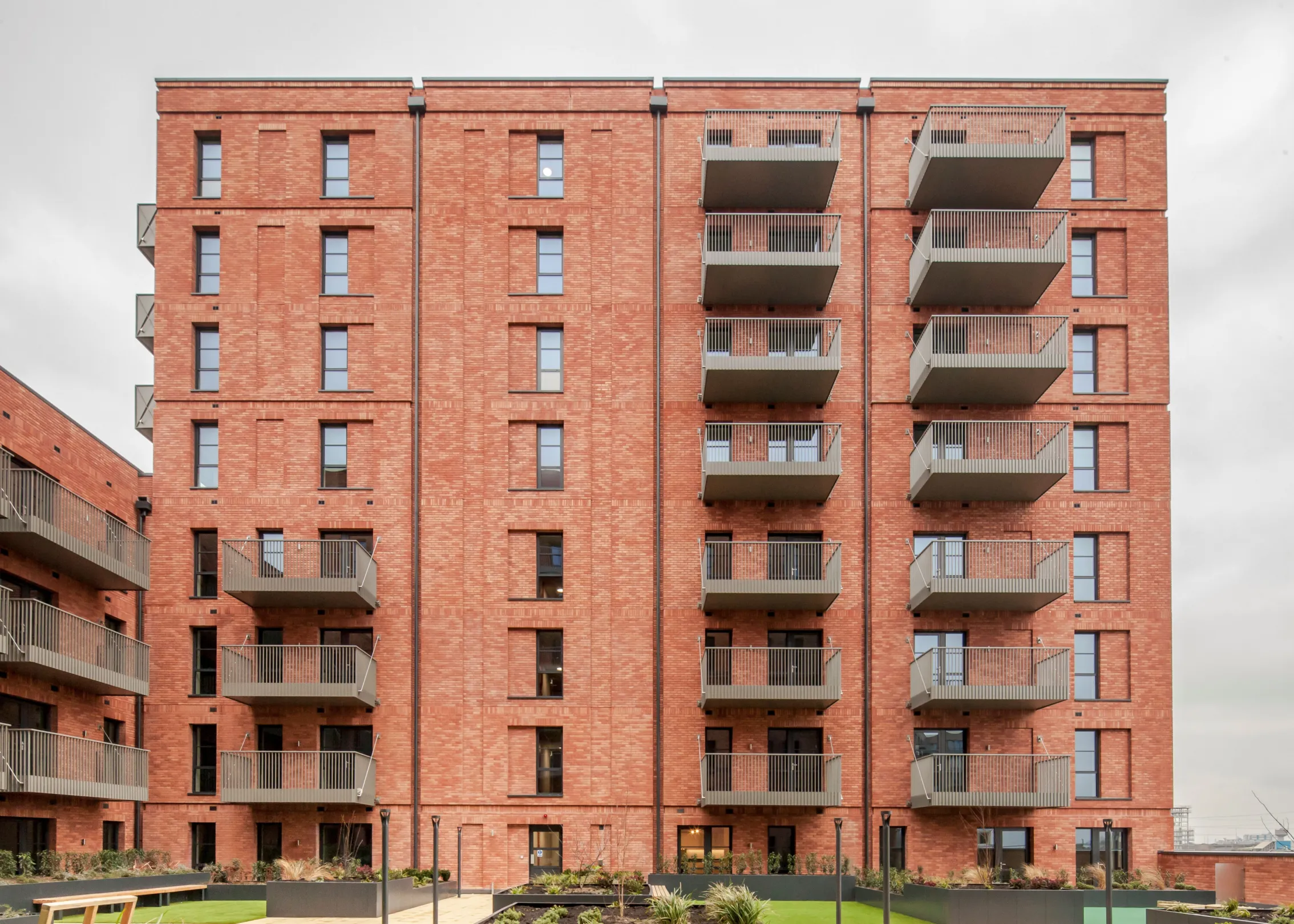 A new build red brick building with green roofs in Dagenham
