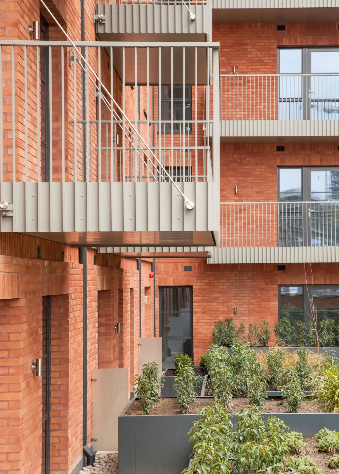 A new build red brick building with green roofs in Dagenham