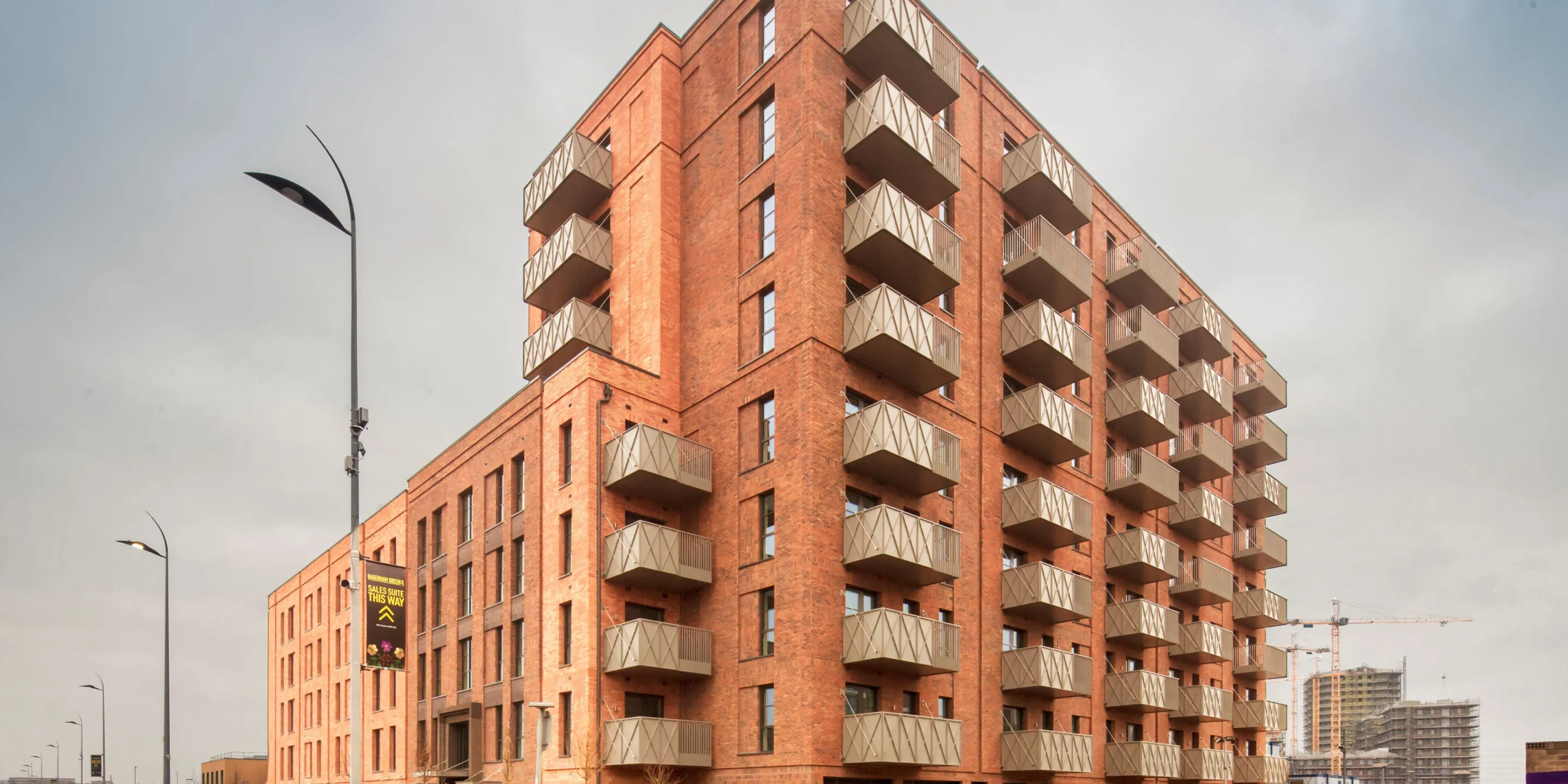 A new build red brick building with green roofs in Dagenham