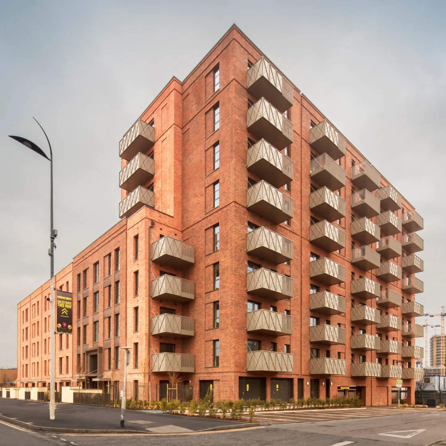 A new build red brick building with green roofs in Dagenham
