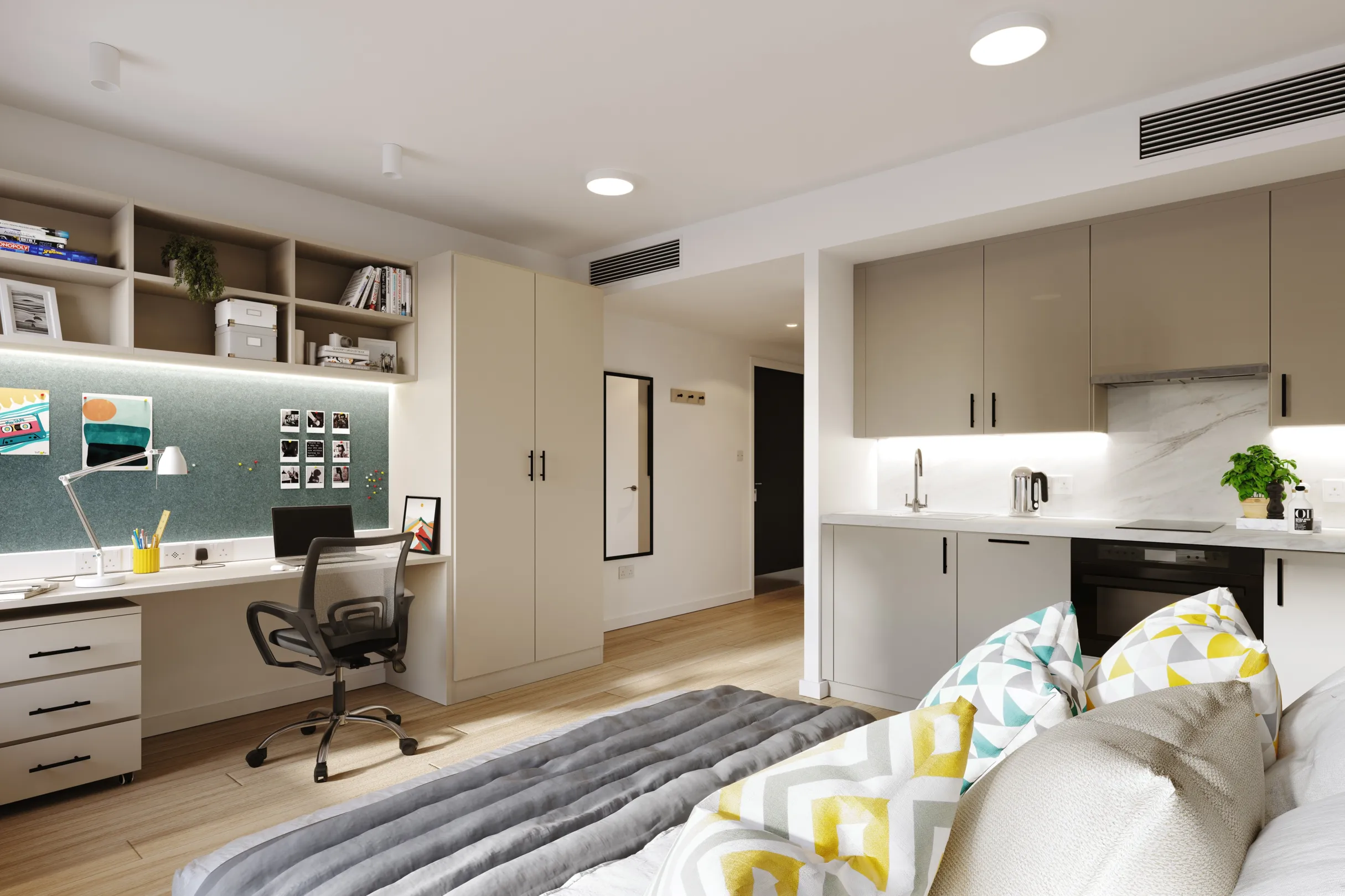 A studio room with bed, desk and chair, wardrobes and mini kitchen in a new student accommodation block